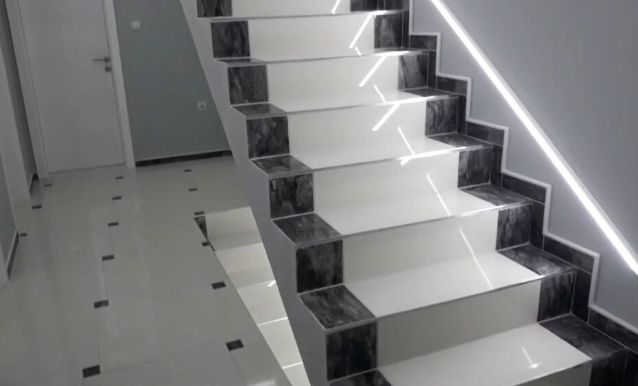 Moderno unutrašnje stepenište sa LED rasvetom i kontrastnim pločicama u hodniku