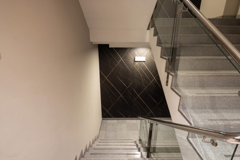 Unutrašnje stepenište sa dekorativnim zidnim osvetljenjem i staklenom ogradom