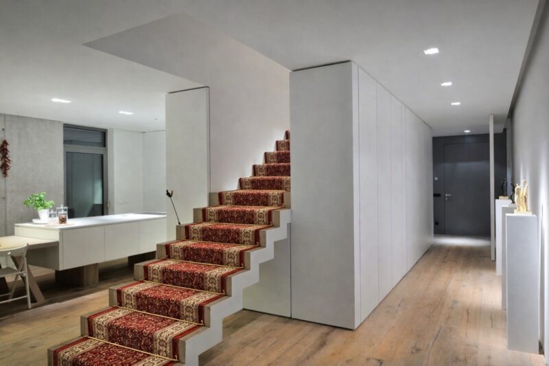 Unutrašnje stepenište sa dekorativnom tepih stazom u modernom enterijeru