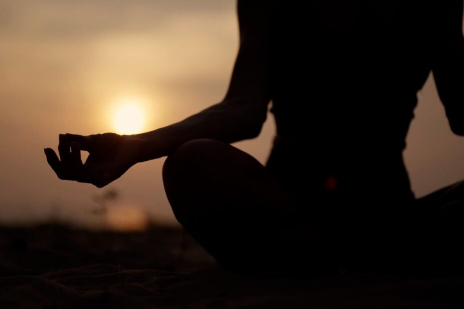 prikaz devojke koja meditira na zalasku sunca