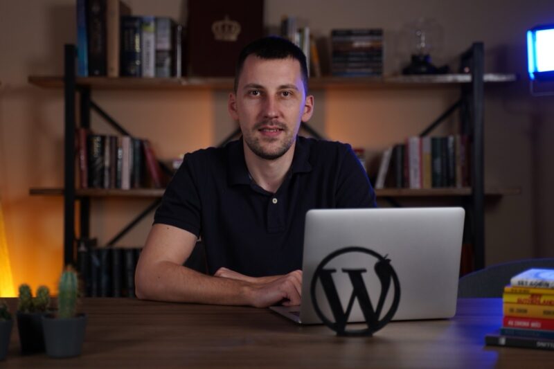 Aleksandar Đekić sedi za laptopom i govori o prednostima WordPress platforme.